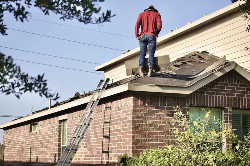 Professional roofer working on a residential roof in Fields of Harvest